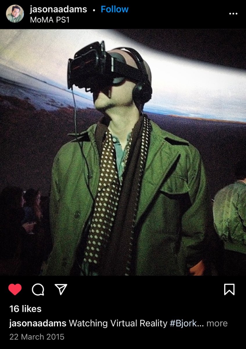 A visitor in a green jacket wearing an early VR headset at the Björk Digital premiere, MoMA PS1.