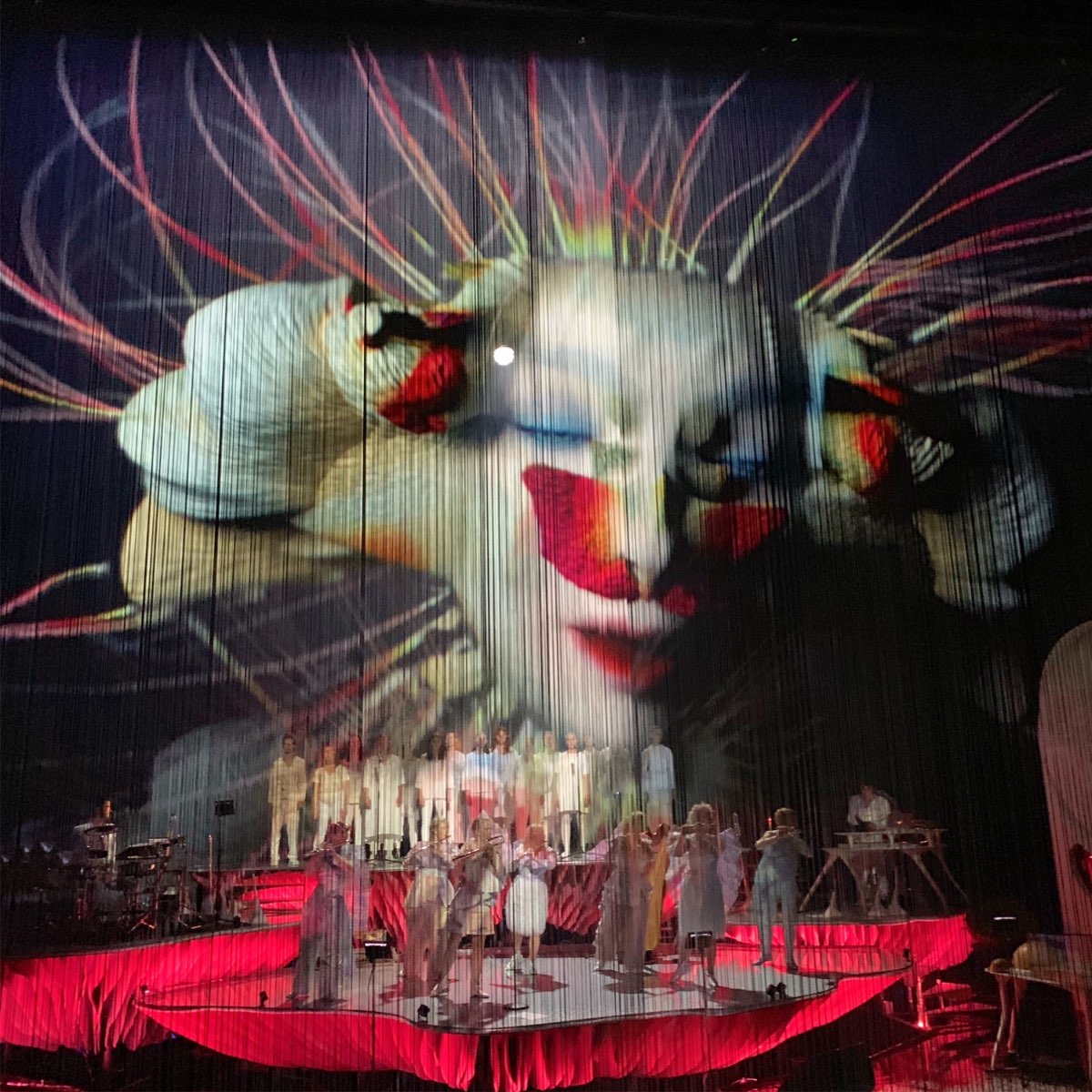 A giant projected face above the Cornucopia stage.