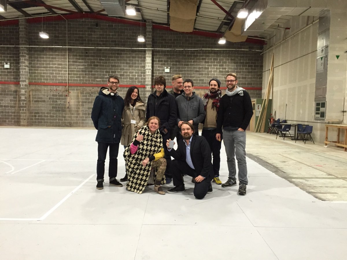 The production team gathered in a warehouse install space.