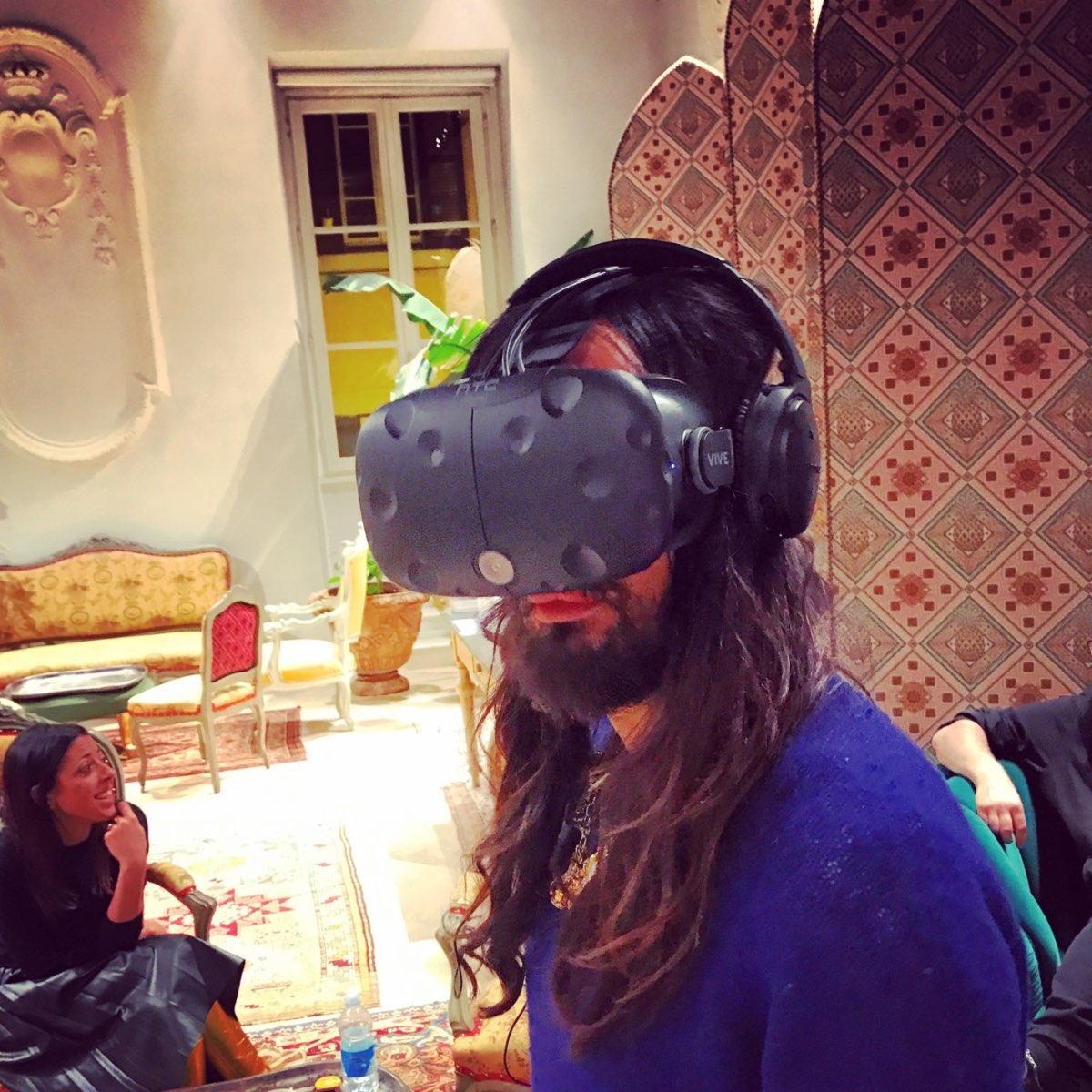 Alessandro Michele trying an HTC Vive headset in an ornate room.