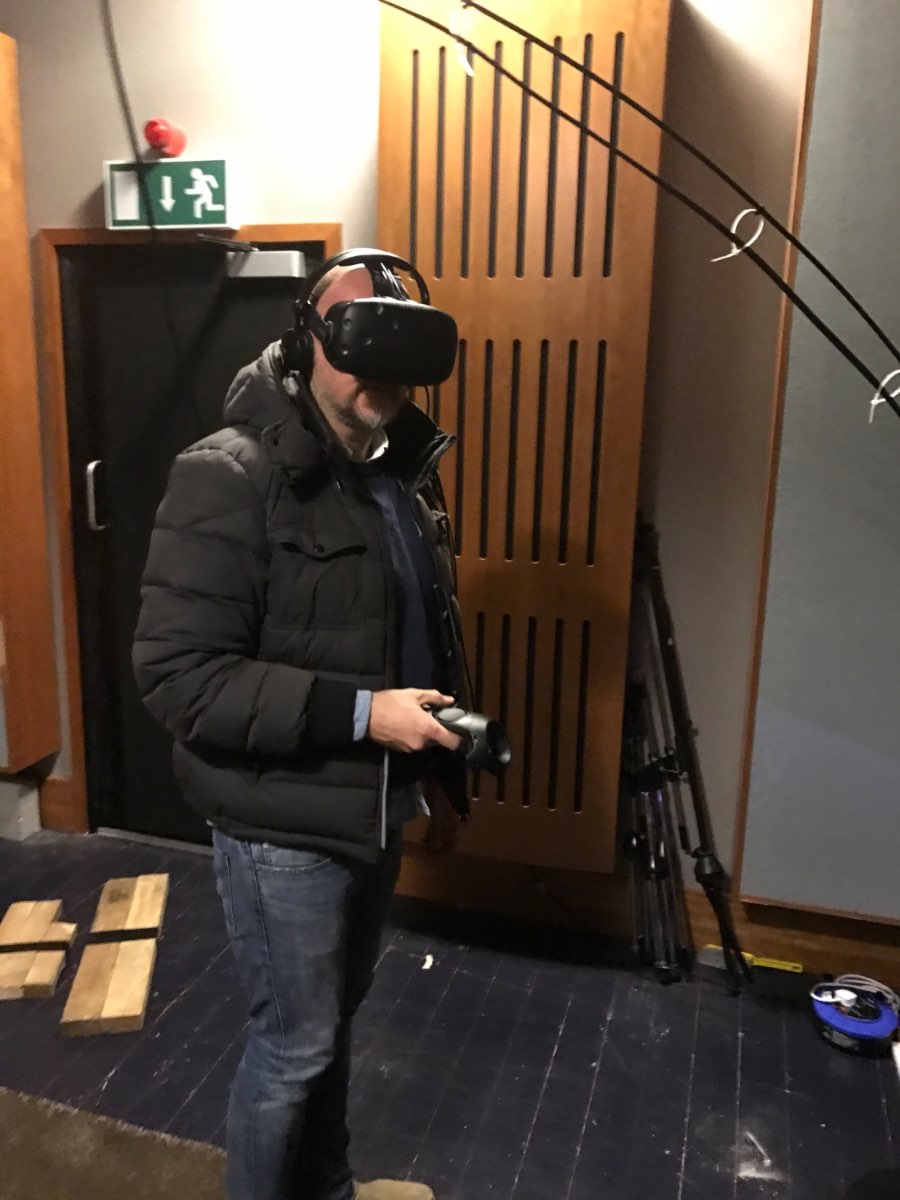 Andrew Melchior in a VR headset holding a controller in the studio.