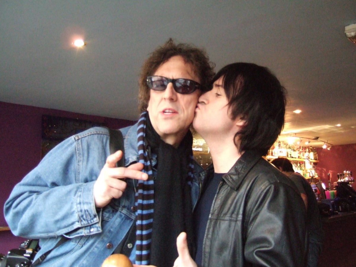 Mick Rock and Andrew Melchior close together in a bar.