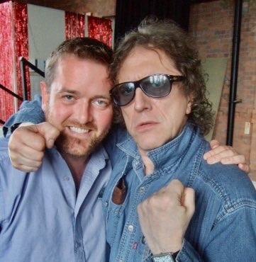 Andrew Melchior and Mick Rock, fists raised playfully.