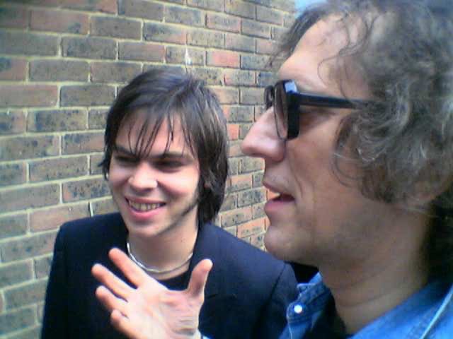 Two men against a brick wall on location.