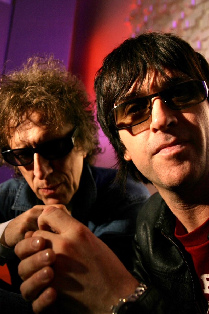 Mick Rock with a musician under coloured light.