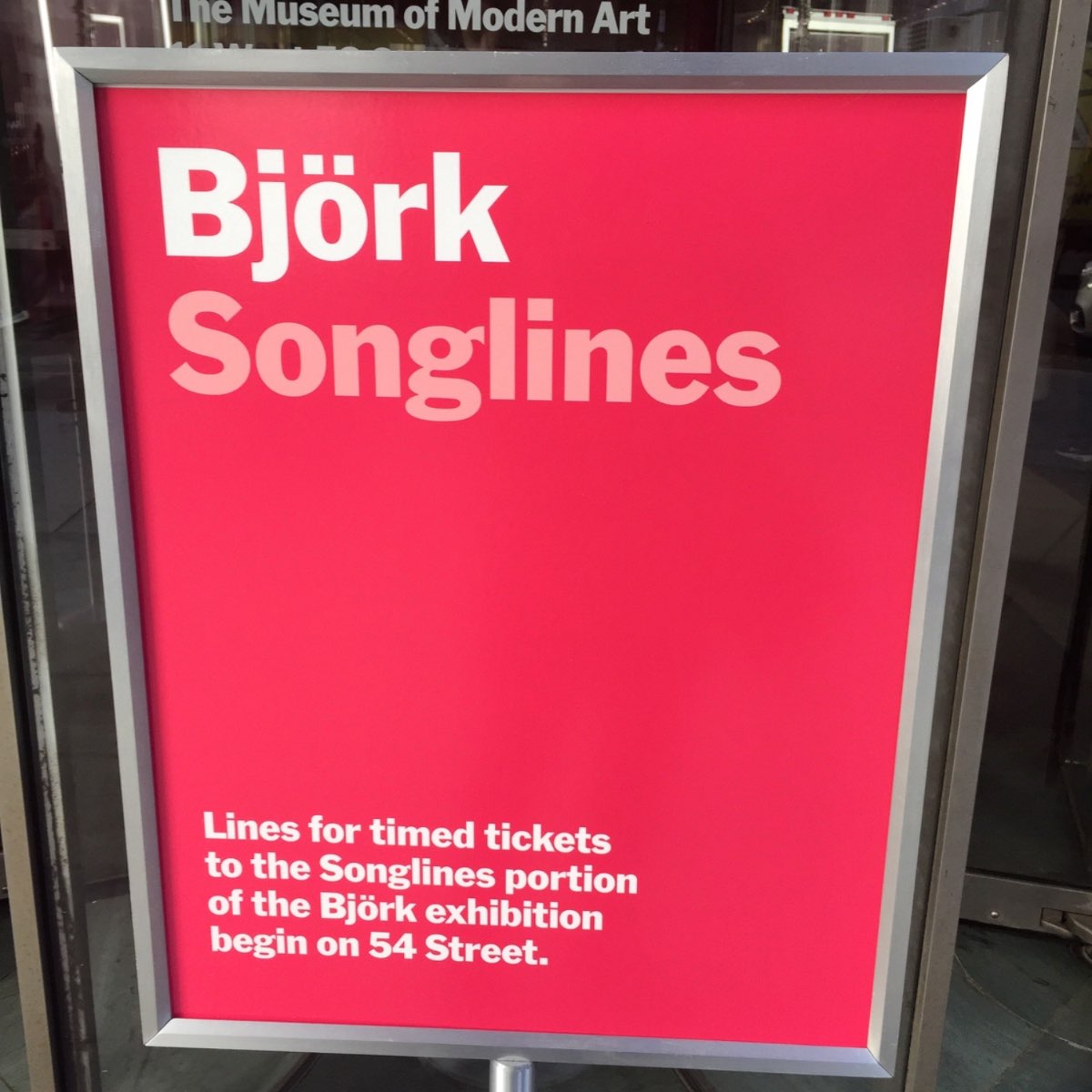 MoMA 'Björk Songlines' signage in the artist's handwritten script on a magenta wall.